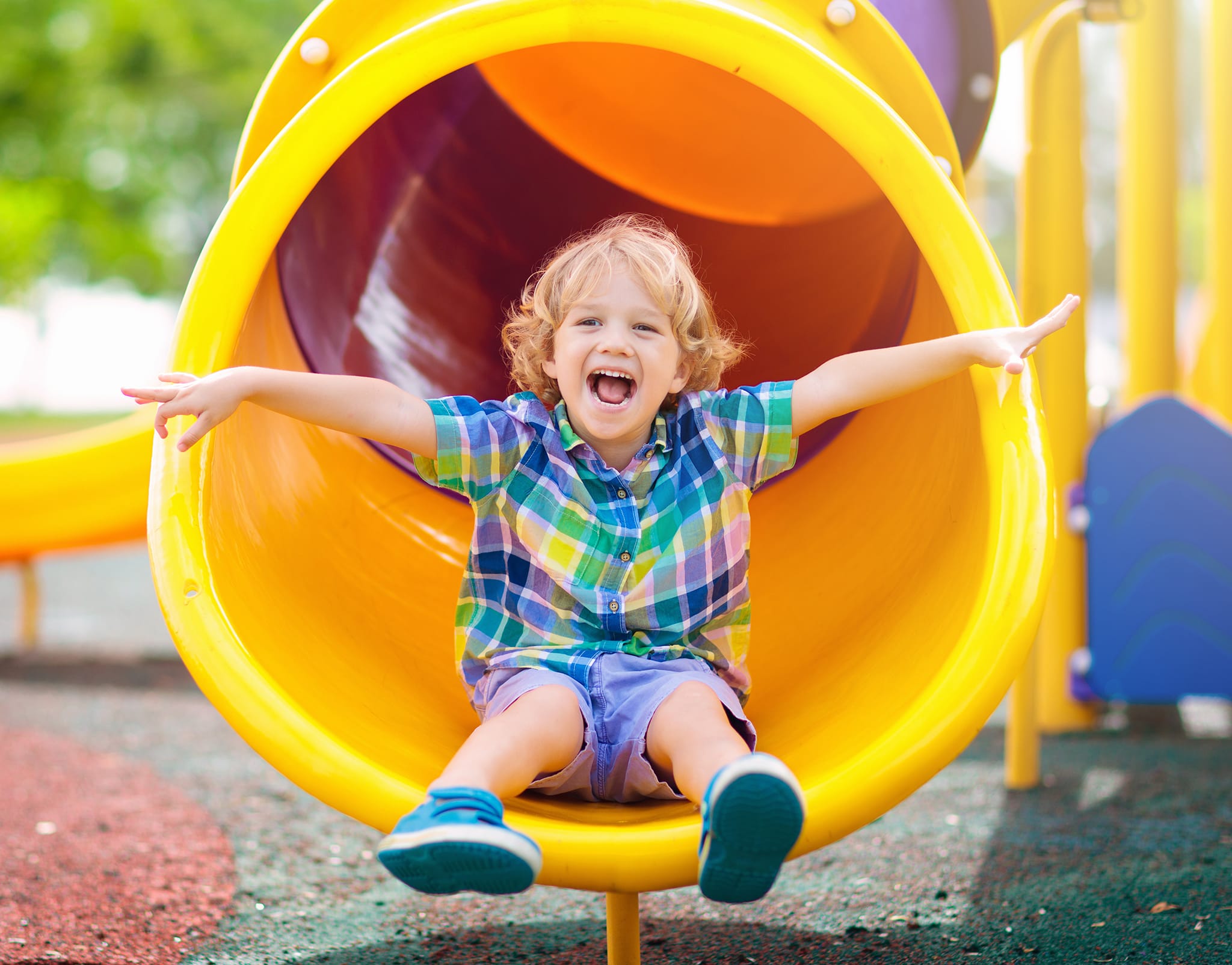 A happy child enjoys outdoor play at a preschool and daycare centre, developing early childhood skills through active learning.